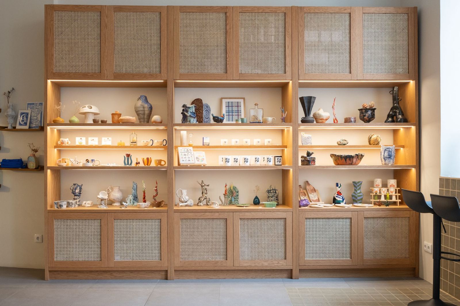 Taro, Lisbon: oak display wall with cane doors and lit shelves