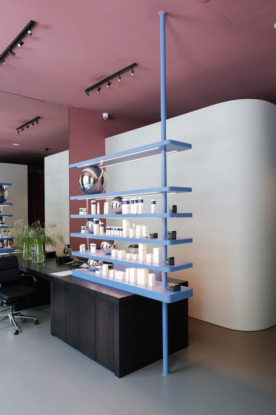 Pause studio: blue shelving on a steel pole and dark oak reception